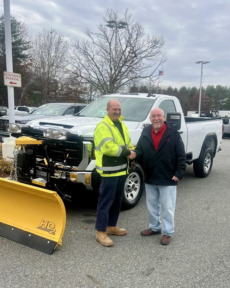 A customer taking delivery of a GMC Sierra 2500HD with a Fisher HD2 plow at Marty's GMC in Kingston, MA